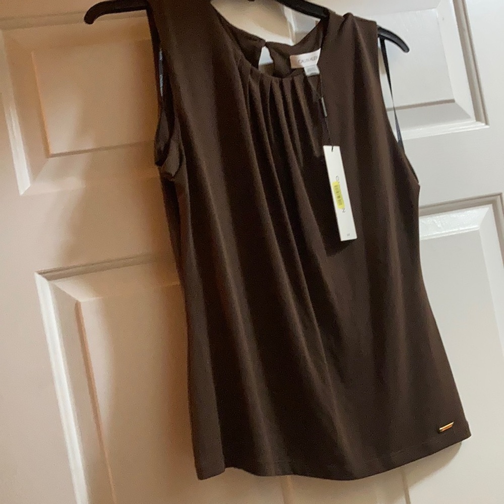 It’s a Calvin Klein blouse size medium and the color is brown!
